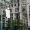 Apple subscription prices 20 percent increase – Ars Technica Transparent walls of modern company building with label icon against old building in downtown