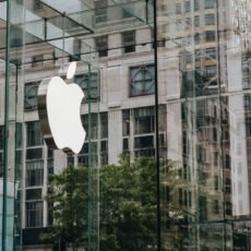 Transparent walls of modern company building with label icon against old building in downtown