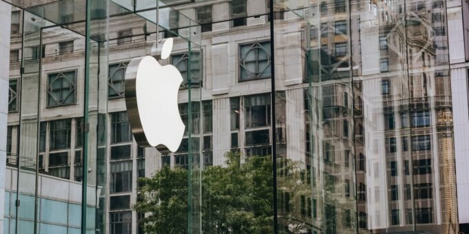 Transparent walls of modern company building with label icon against old building in downtown