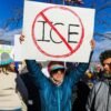 Woman Released From ICE Custody Froze to Death Protester holds sign with "no ice" symbol.
