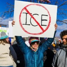 Protester holds sign with "no ice" symbol.