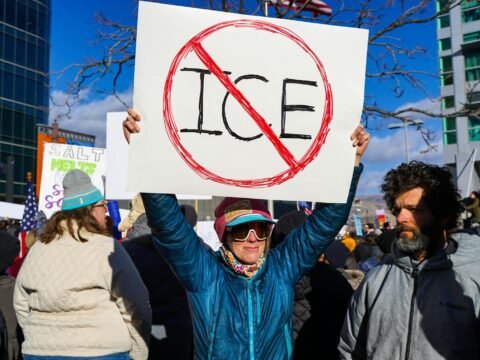 Protester holds sign with "no ice" symbol.