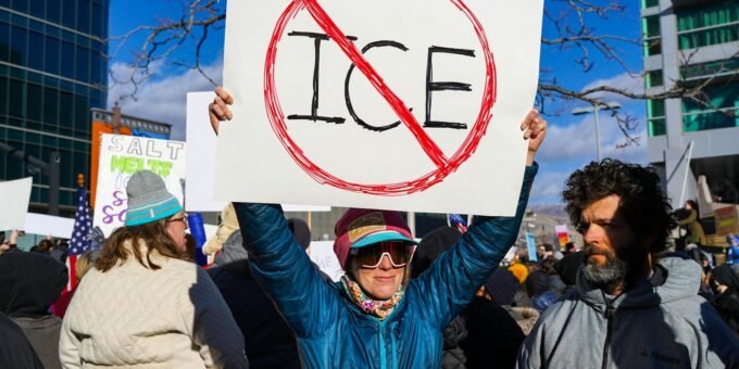Protester holds sign with "no ice" symbol.